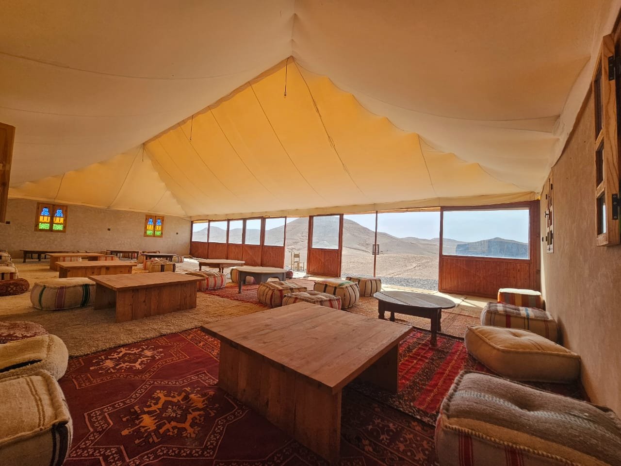 Lounge tent with cushions and low tables at the camp