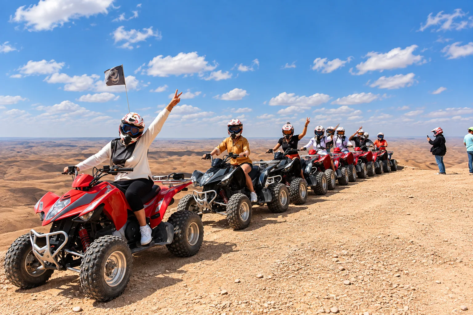 Rider waving from a red quad at the head of a long convoy, quad biking in the Agafay desert on a sunny day
