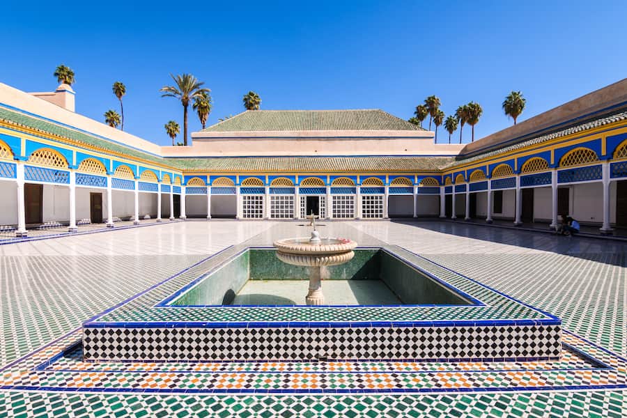 Zellige-tiled fountain basin in the great courtyard of Bahia Palace under a blue sky, Marrakech guided tour