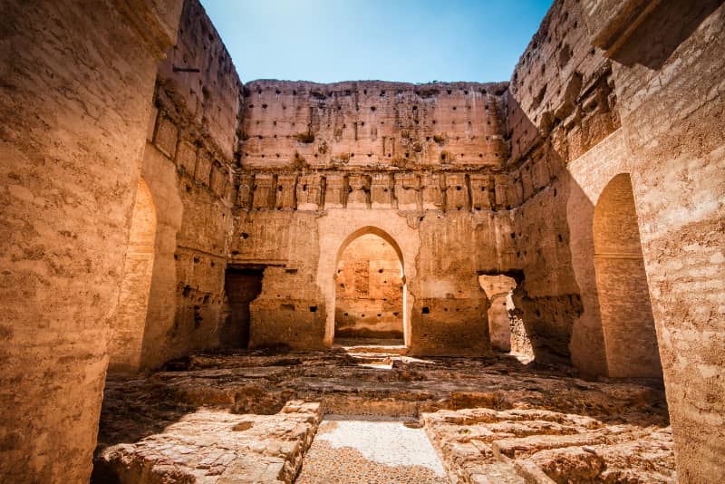 Crumbling earthen walls and an arched doorway in the ruins of El Badi Palace, Marrakech guided tour