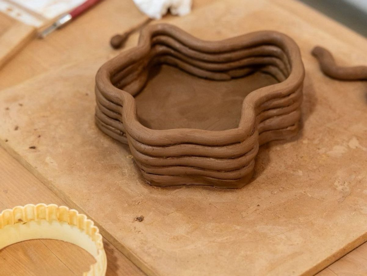 Ciotola a stella fatta con colombini di argilla sovrapposti su un'asse di legno, corso di ceramica a Marrakech