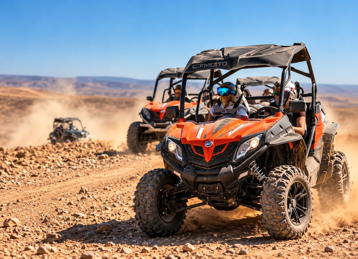 Orange buggies racing in a dust cloud on a stony trail during a buggy ride in the Agafay desert
