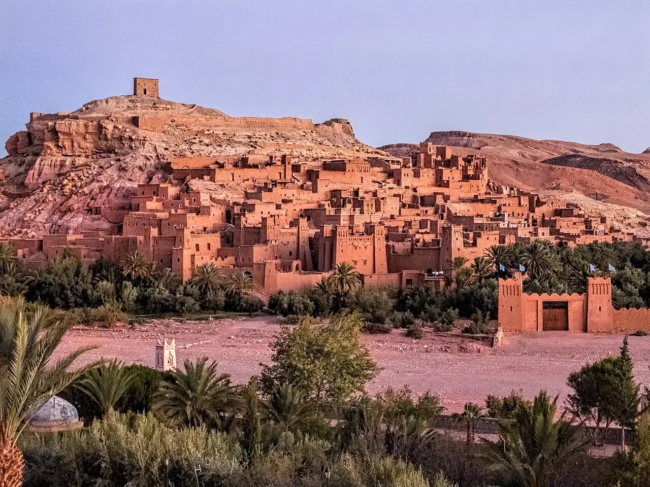 Red earthen kasbahs stacked up the hill with a tower at the summit, Aït Ben Haddou day trip from Marrakech