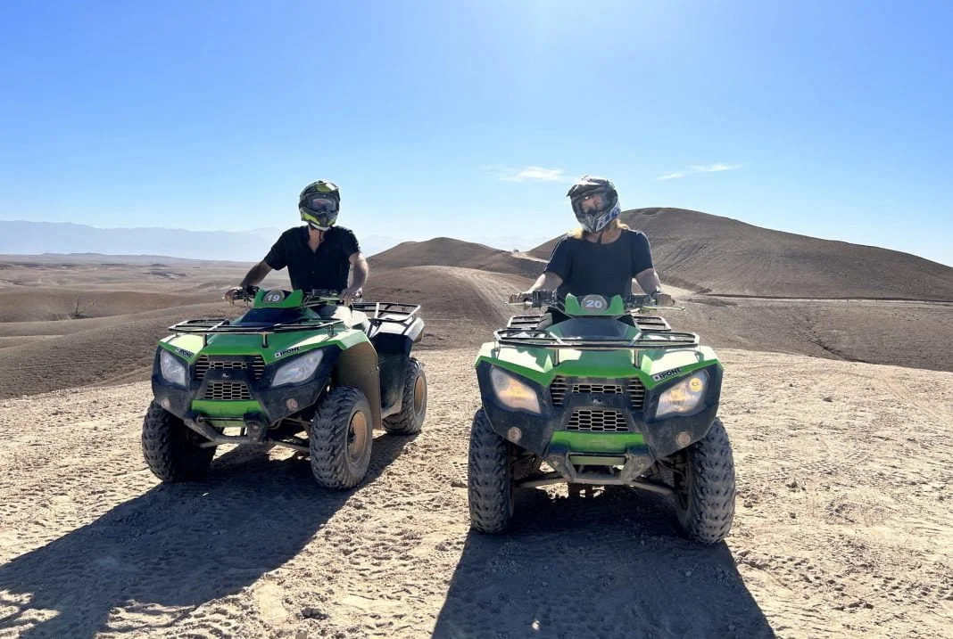 Due persone su quad verdi tra le colline sassose di Agafay, attività vicino al day pass in piscina The White Camel